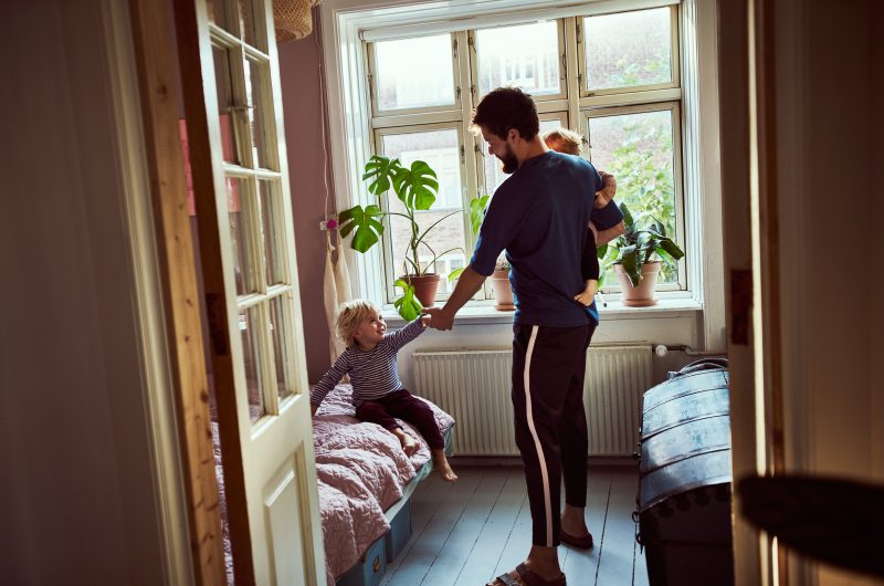 Full length shot of a young man trying to get his children ready in the morning