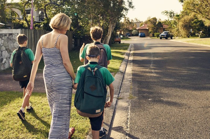 Shot of a mother walking three boys to school